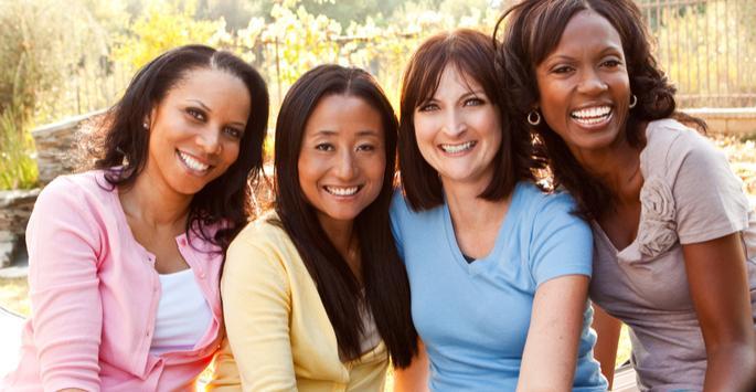 women grouped together and smiling