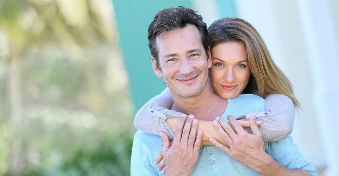 man and woman smiling and hugging