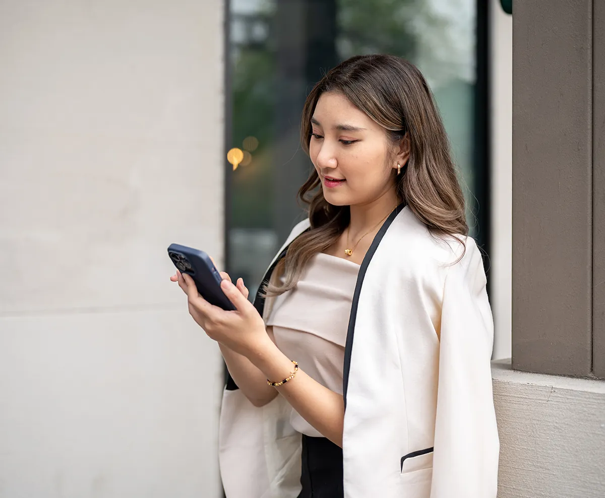 elegant young woman using her phone to redeem beauty rewards