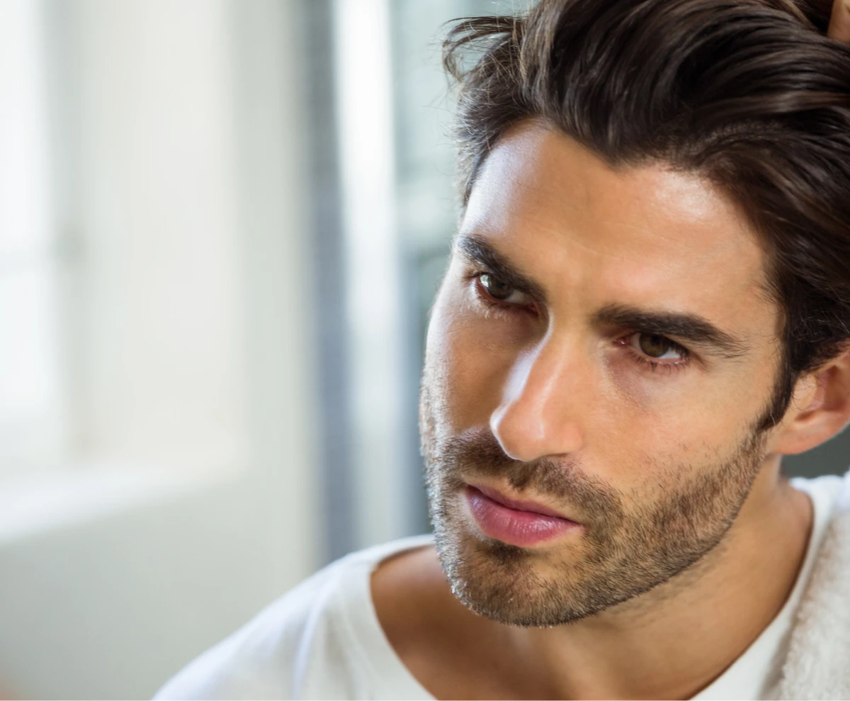 young man looking in the mirror at his appearance